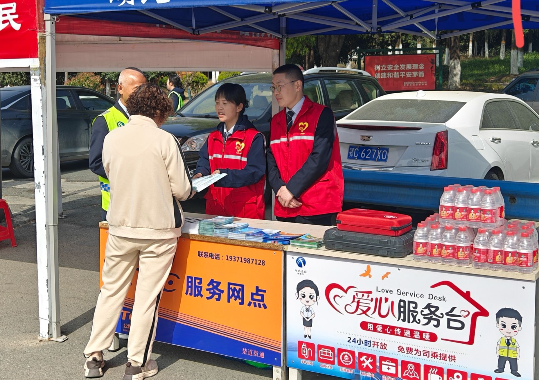 AiLu志愿者在收費(fèi)廣場向過往司乘宣傳國家安全教育日手冊.png.png
